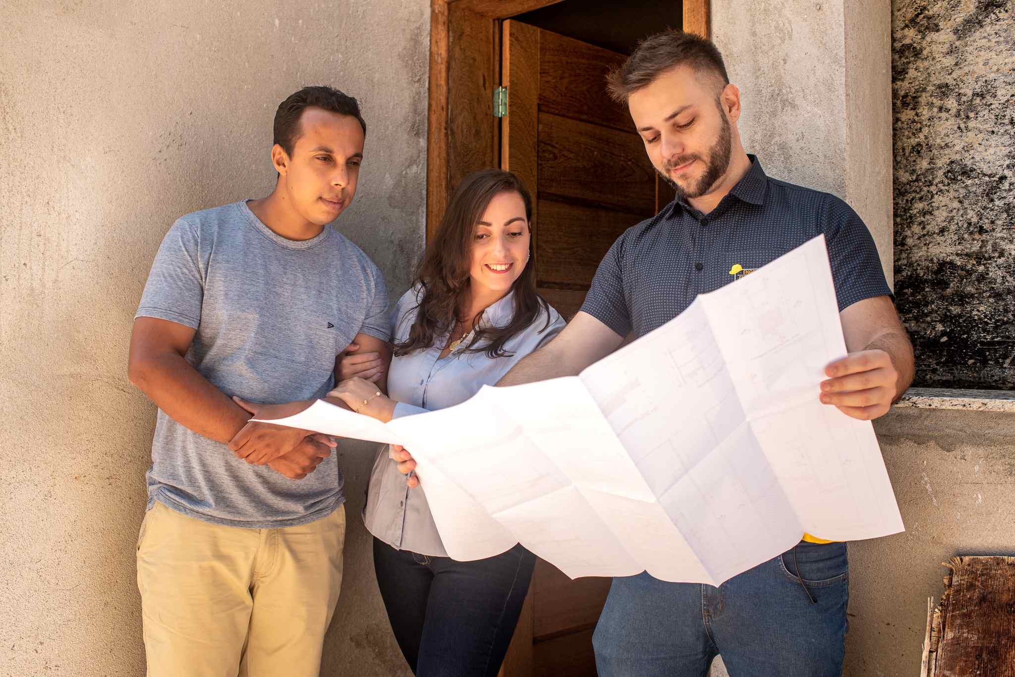 Família trabalhando com engenheiro analisando plantas da casa